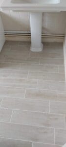 Limed oak porcelain plank style tiles in a bathroom with white basin and bath