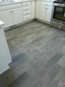dark grey granite effect porcelain tiling of a kitchen floor in a brick pattern
