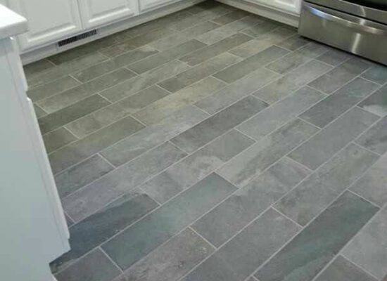 dark grey granite effect porcelain tiling of a kitchen floor in a brick pattern