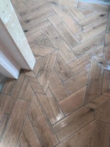 Wood effect porcelain tiles laid on a floor in a herringbone pattern