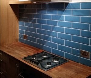 Royal blue ceramic metro tiles used as a kitchen splashback behind kitchen worktop