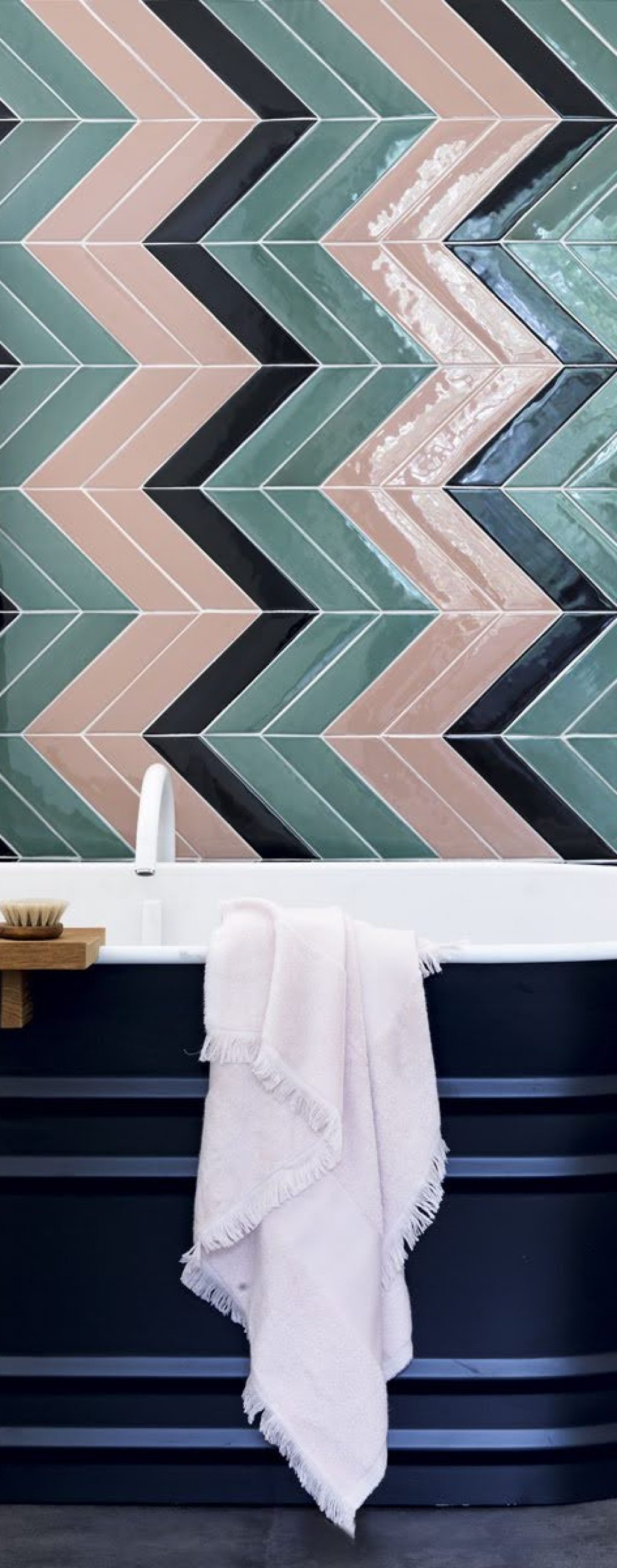 Bathroom tiles in pink and green in a chevron design