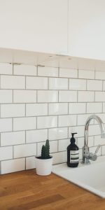 Small gloss white metro tiles on a splashback behind a kitchen sink